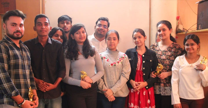 Students holding trophies after receiving academic awards